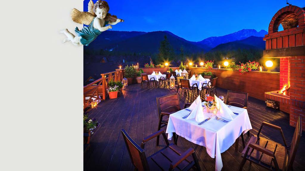 Restauracja Pod Aniołem Urządzona na wzór góralskiej izby - stoły i ławy z jasnego drewna, na ławach miękkie poduchy, na kominku ludowe figurki aniołów, błękitne dekoracje.