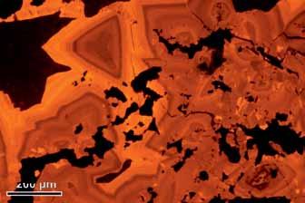 Chalcocite (black) replaces calcite, unfilled voids (yellow) are visible