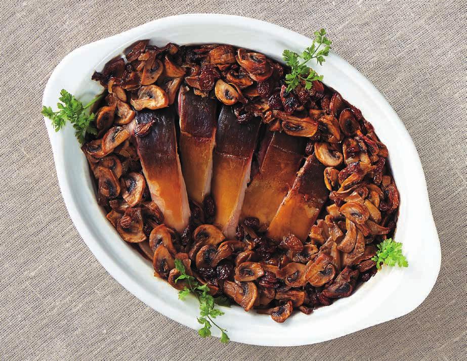 Karp w pieczarkach z rodzynkami Grażyna Cichańska, KGW Janowo 1½ kg sprawionego karpia (w całości, bez głowy) 100 ml białego wytrawnego wina 2 garście rodzynek 60 dag pieczarek 3 łyżki masła sól do