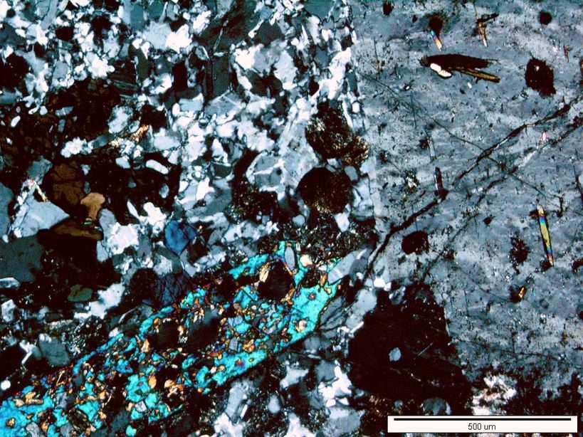 ) tworzący kryształy dochodzące wielkością do 1 cm, obok którego występuje albit (ok. 20% obj.) oraz augit (do 10% obj.) i pozostałe minerały do 4%.