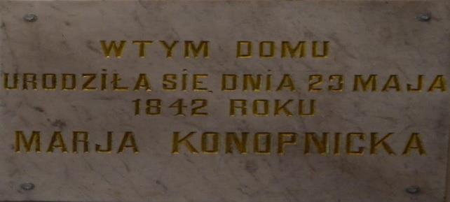 wielkości rzeźbą przedstawiającą poetkę, ulica i nowoczesny plac w centrum miasta z