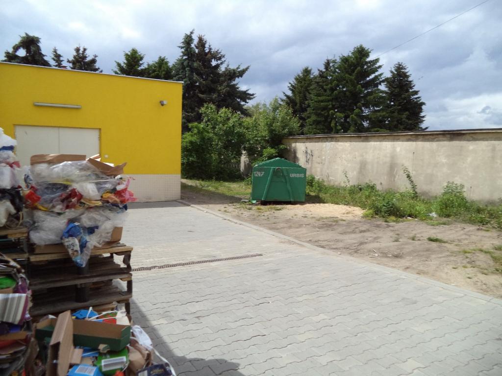 W kontenerze nie jest gromadzona makulatura i plastik. Świadczyć o tym może sterta kartonów i folii zgromadzona przy ścianie budynku, co prezentuje załączona fotografia.