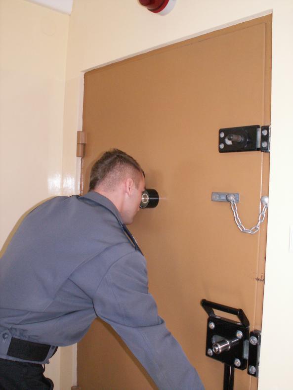 16 Zdjęcie nr 3. Kontrola zachowania się osób umieszczonych w pokoju bez otwierania drzwi Kontrolując zachowanie osób, policjant nie otwiera drzwi pokoju, w którym znajdują się osoby.