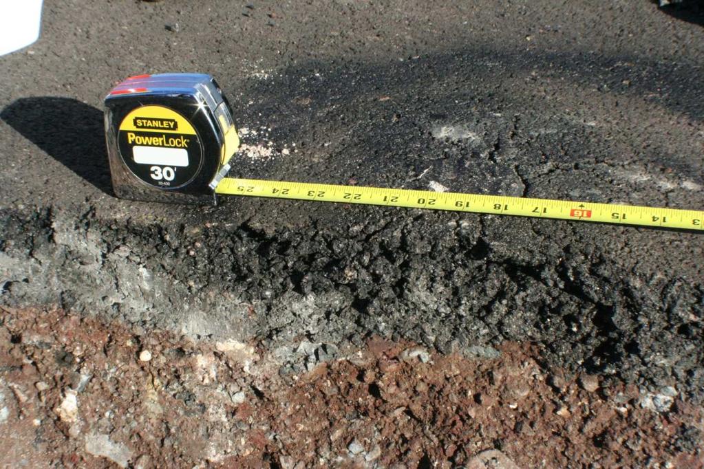zmian na powierzchni, usunięto wierzchnią warstwę asfaltu w pobliŝu wybrzuszenia (rys. 2b), a następnie ręcznie wybrano materiał znajdujący się poniŝej.