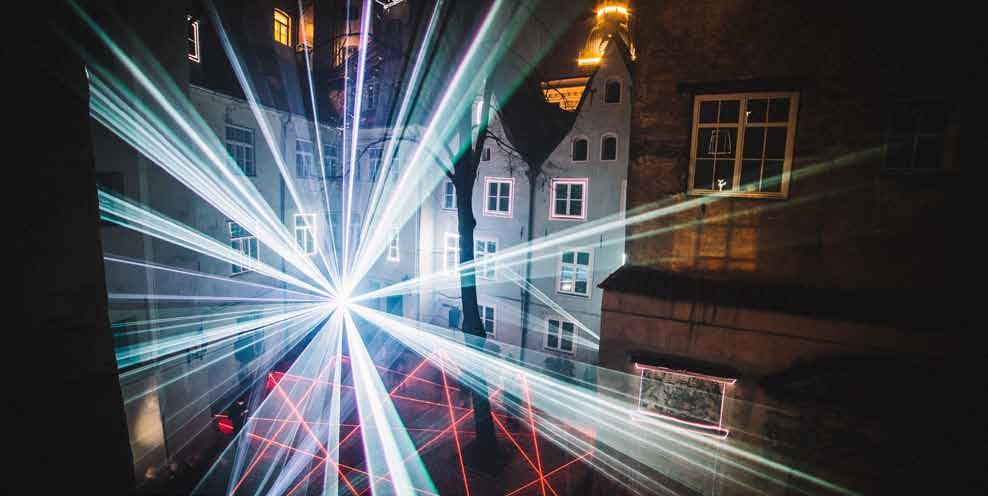 widzów. W atmosferze podobnej do snu, tańczące promienie laserów, mnożące się przy ziemi, nabierające objętości w górze, wydobywają z otaczającej architektury każdy szczegół jej geometrii.