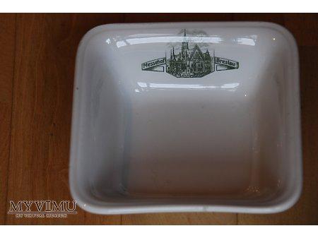 Miska Messehof Breslau 209-0-02 Miska Messehof Breslau 925 Miska z restauracji Messehof Breslau. Wymiary: góra,5 cm, dół 7 cm, wysokość 5 cm. Wytwórnia porcelany Krister Porzellan-Manufaktur A.G.