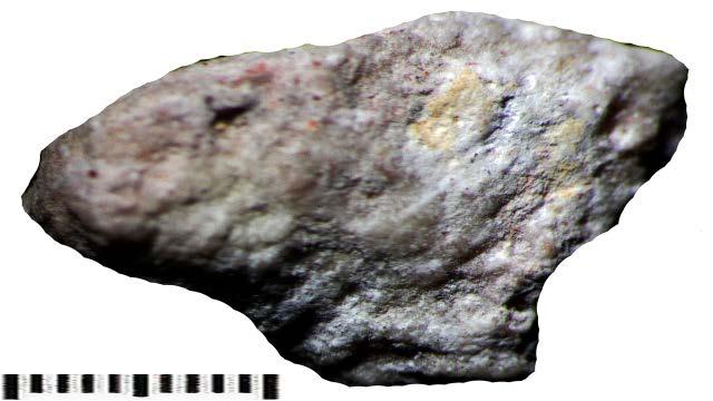 fragment wapienia ujawnia szereg interesujących cech. Na jednej stronie próbki widoczne są czerwone plamki hematytowe oraz ślady po narzędziu (Fot. 4) Fot. 4 Fragment skały z puzdereczka.