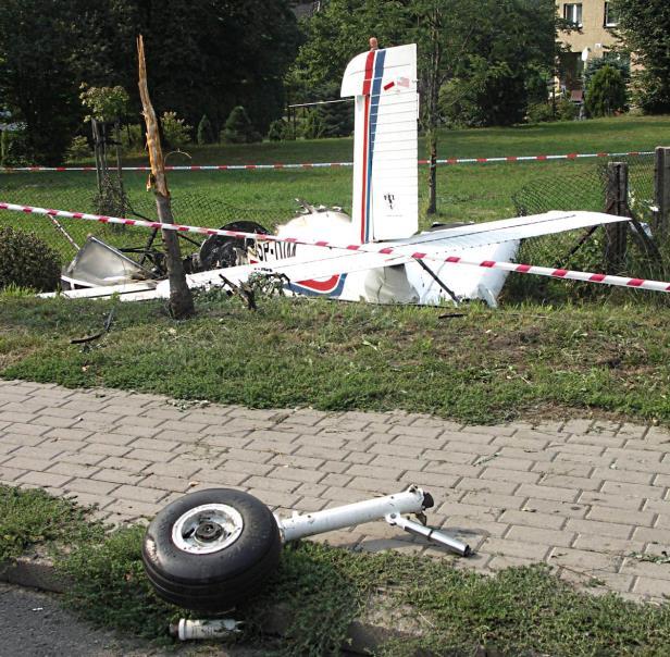 Na pierwszym planie widoczne odłamane lewe podwozie główne, dalej