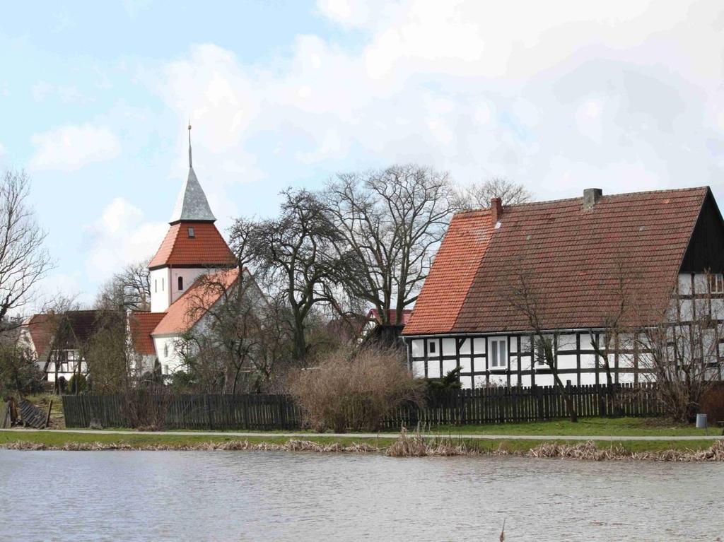 Walory wsi wg KOM pozytywy (1) Centrum / miejsce centralne (I.A.1.3) - ocena wybitna 2 pkt. Fot. SW_WP1. Widok na centrum wsi. Na pierwszym planie Zagroda nr 38, z lewej Kościół filialny pw.