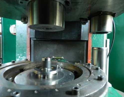 Press used in research work: (a) general view, (b) mechanism of bilateral rotated punch Zestaw narzędziowy składał się z pojemnika (recypient) o średnicy 40,5 mm i obrotowego stempla z