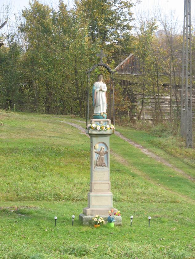 Obok domu Alicji i Stanisława Załęskich stoi kamienny posąg Najświętszej Maryi Panny Królowej Wszechświata na ogzymsowanym postumencie z płaskorzeźbami: św.
