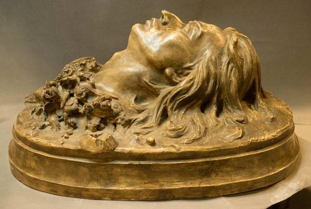 Na prawym ramieniu zmarłego leży zwój z zapisem nutowym i wyrytym tytułem Marche funebre.