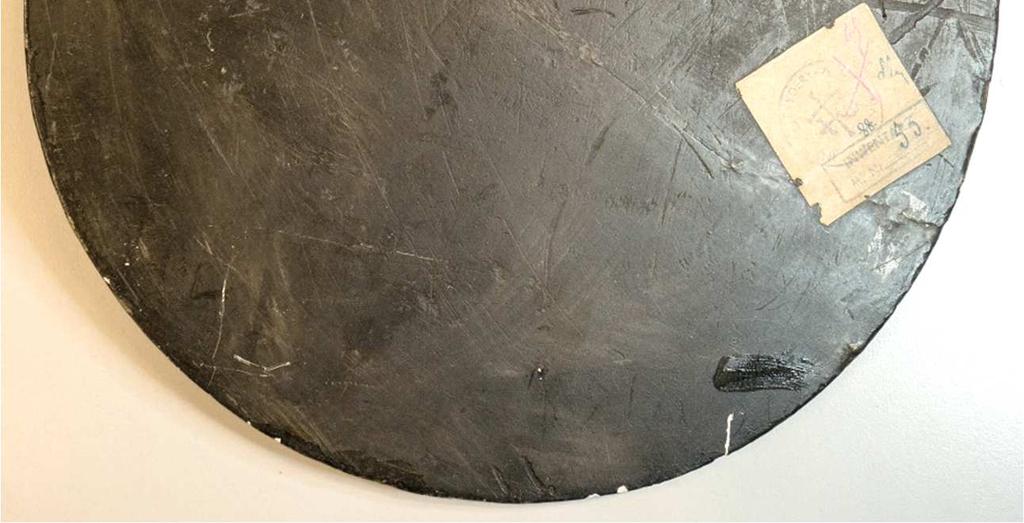 Dwie papierowe naklejki inwentaryzacyjne. Metalowe ucho do zawieszania. Wymiary obiektu: Ø 31 cm, wysokość 3 cm 2. STAN ZACHOWANIA Obiekt zachowany w stosunkowo dobrym stanie.