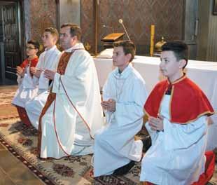 ministranci ze świecami, służący przy ołtarzu, diakon niosący ewangeliarz, kapłan.