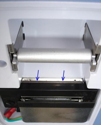 1), nacisnąć klawisz FEED w celu przewinięcia papieru przez mechanizm drukarki, osadzić nową rolkę papierową w kasecie drukarki z wykorzystaniem srebrnej rolki, przełożyć wysunięty fragment papieru