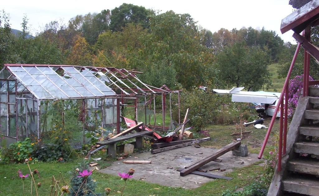 19 Uszkodzony przez lewe skrzydło samolotu budynek szklarni, na drugim planie