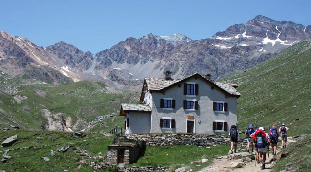 72 TREKKING W ALPACH Stary domek myśliwski niedaleko schroniska Rifugio Vittorio Sella przez skute lodem grupy Roccia Viva i Tribolazione, stoi grupka szałasów pasterskich.
