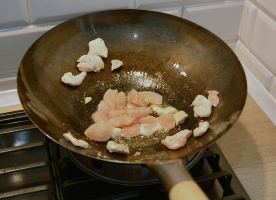 Wtedy wrzucamy jednocześnie imbir, czosnek i chili. Smażymy dosłownie kilka sekund i przelewamy zawartość woka przez sitko. Imbir, czosnek i chili możemy zachować w sitku lub wyrzucić.