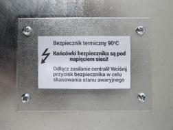 Przycisk kasowania bezpiecznika ręcznego znajduje się w oznaczonym miejscu obudowy centrali wentylacyjnej.