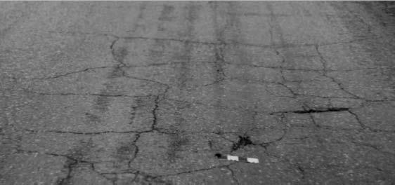 szczegółowym. Zadanie 12. Przedstawione na zdjęciu uszkodzenie nawierzchni, zinwentaryzowane w Systemie Oceny Stanu Nawierzchni (SOSN), należy zakwalifikować do grupy A. pęknięć siatkowych. B.