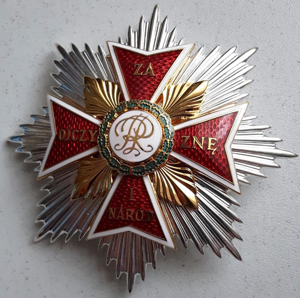 Gwiazda do Orderu Orła Białego Gwiazda orderowa srebrzona o średnicy 80 mm z ośmiu pęków promieni. Na gwieździe umieszczony jest krzyż równoramienny, złocony.