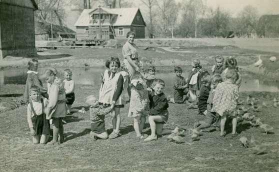 7 Zdjęcie 6 Rok 1952 (około). Zabawy dzieci z przedszkola na łące za dawnym kinem START pod opieką wychowawczyni Janiny.