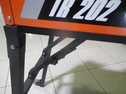 1 Montaż nóg Unieść przecinarkę z jednej strony i