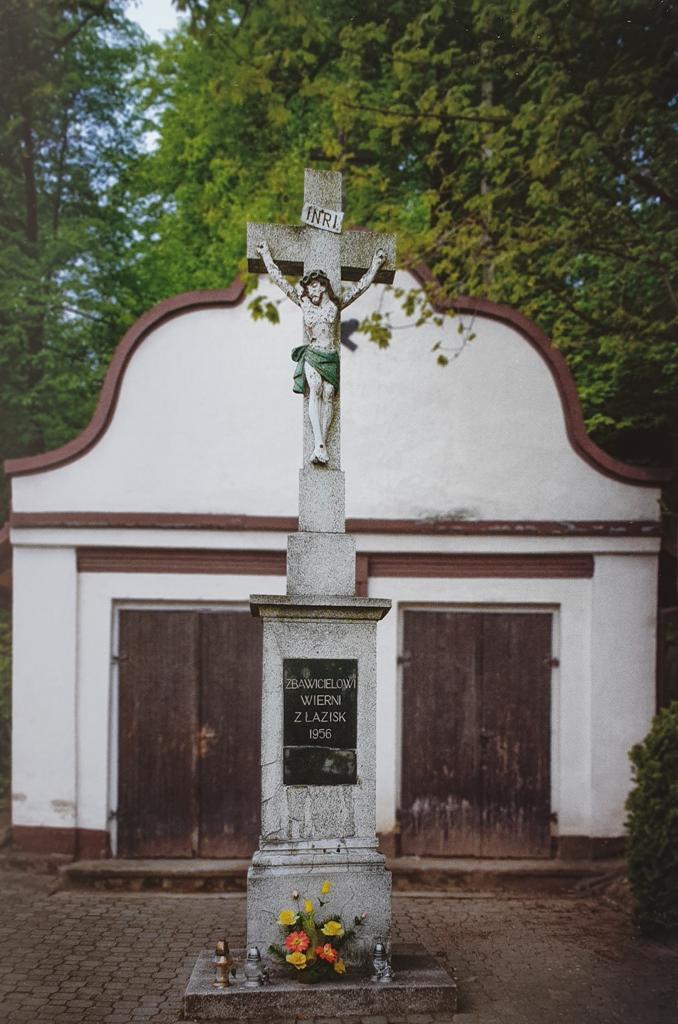 Kamienny krzyż wykonany z lastryko usytuowany jest w górnej części cmentarza przy kościele w Łaziskach.. Nie ma zapisów o potrzebie jego budowy.