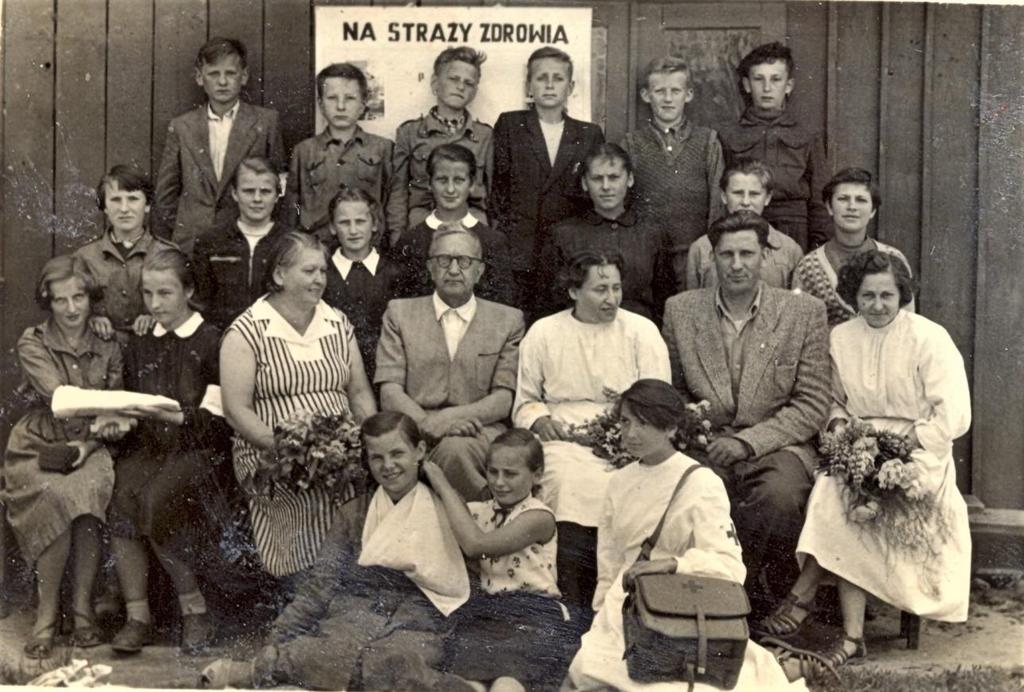 5 Zdjęcie 6 Rok 1958. Zakończenie kursu PCK. W tle budynek szkoły, budynek pocerkiewny, współcześnie nieistniejący. Budynek był usytuowany prostopadle do budynku dawnego internatu.