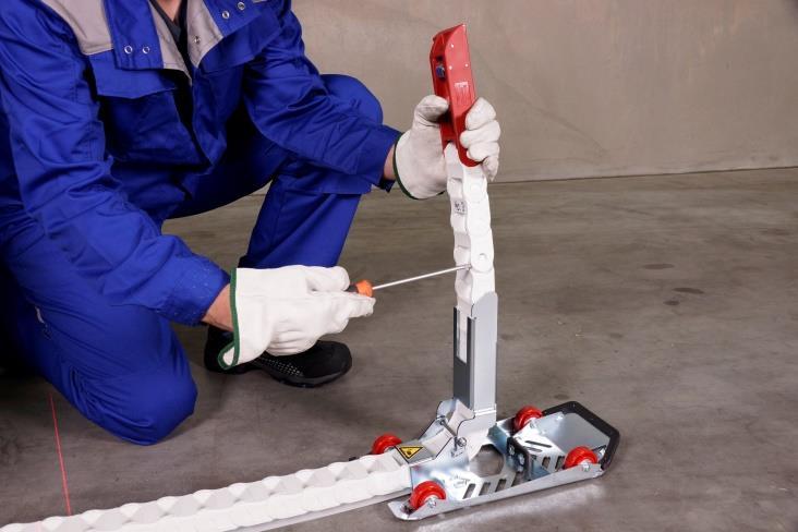 Wyciągnij mechanizm prowadzący na odległość około 1 m od urządzenia, zegnij
