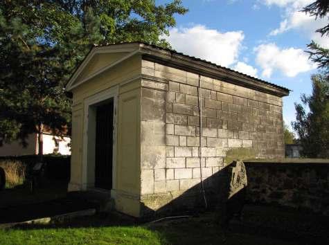 Elewacja kaplicy grobowej Budynek na planie zbliżonym do kwadratu, murowany i otynkowany tynkiem zacieranym, elewacja klasycyzującej, dach